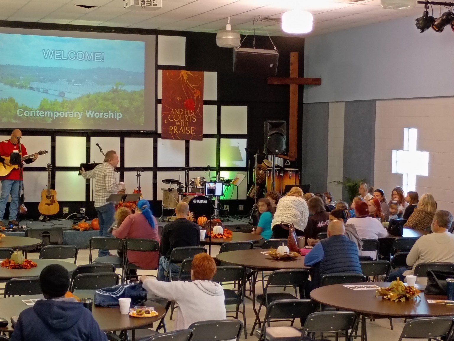 KCMC members gathered around tables for contemporary worship